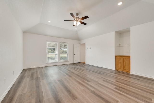 empty room featuring ceiling fan, light hardwood / wood-style flooring, and vaulted ceiling