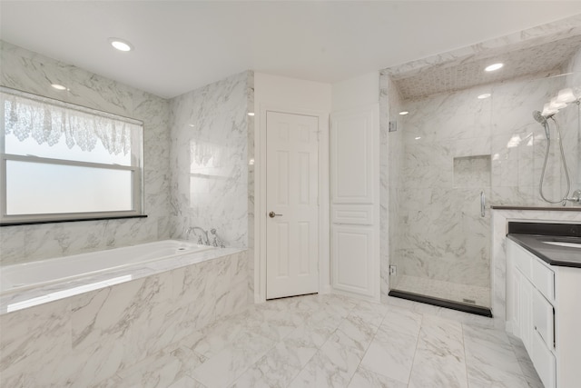 bathroom with vanity and shower with separate bathtub