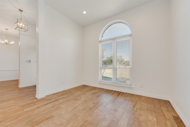 unfurnished room with light hardwood / wood-style floors and an inviting chandelier