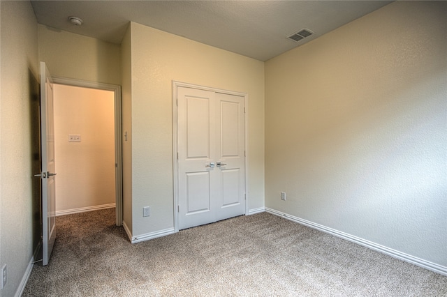 unfurnished bedroom with a closet and carpet