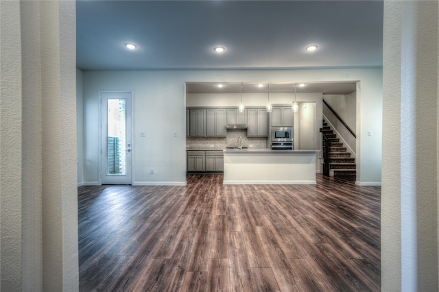 kitchen featuring sink, dark wood-type flooring, stainless steel appliances, backsplash, and gray cabinets