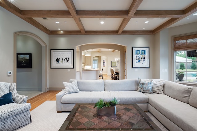 living room with beam ceiling, light hardwood / wood-style flooring, and coffered ceiling