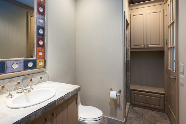 bathroom with decorative backsplash, vanity, and toilet