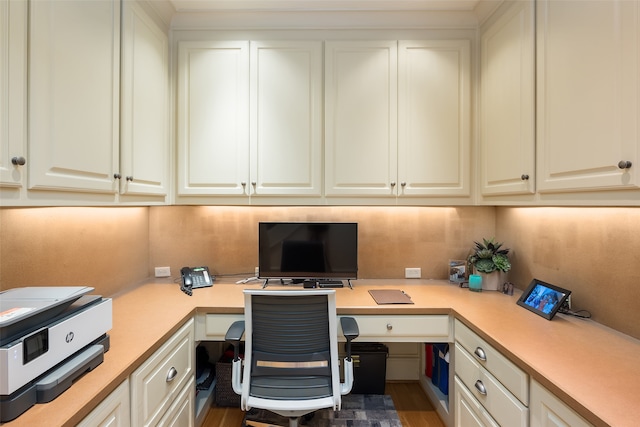 home office featuring wood-type flooring and built in desk