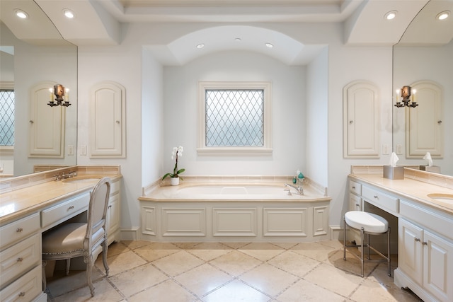 bathroom with a notable chandelier, a tub, and vanity