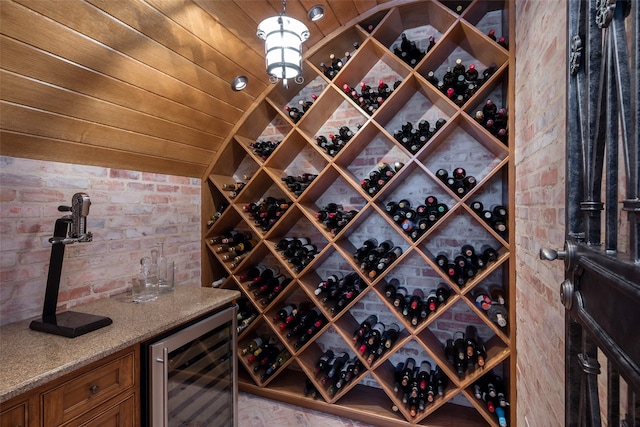 wine room featuring brick wall, wooden ceiling, wine cooler, and vaulted ceiling