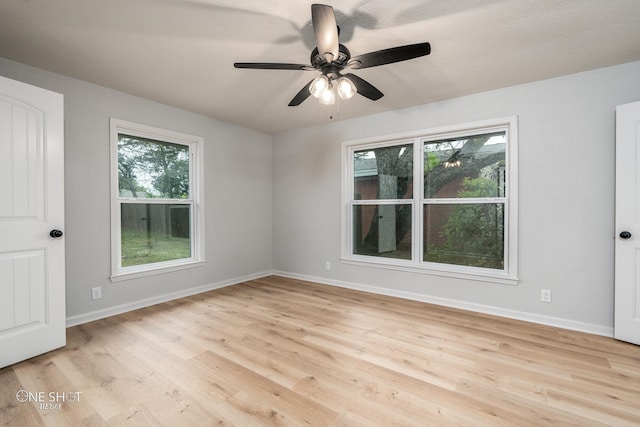 unfurnished room featuring plenty of natural light, ceiling fan, and light wood-type flooring