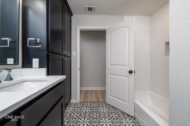 bathroom with a textured ceiling, vanity, and tile patterned floors