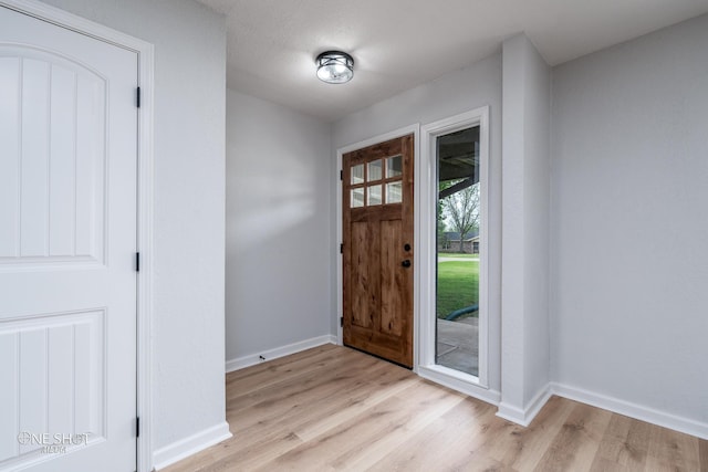 foyer with light hardwood / wood-style floors and a textured ceiling