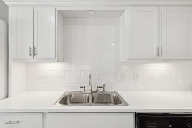 kitchen featuring white cabinets, dishwashing machine, sink, and tasteful backsplash