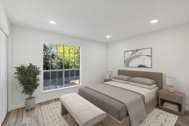 bedroom with light hardwood / wood-style flooring and a closet