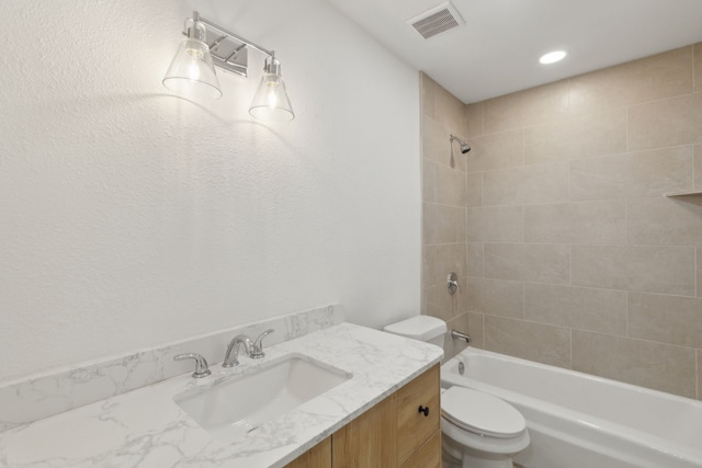 full bathroom featuring vanity, toilet, and tiled shower / bath