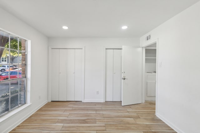 unfurnished bedroom featuring multiple closets