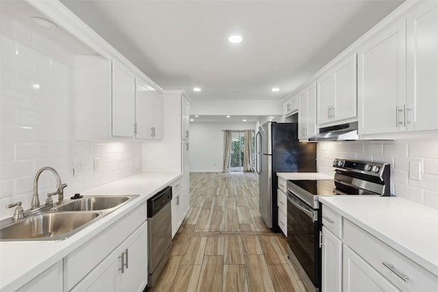 kitchen with tasteful backsplash, sink, white cabinets, and stainless steel appliances