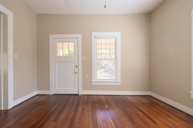 foyer entrance with a textured ceiling and dark hardwood / wood-style floors