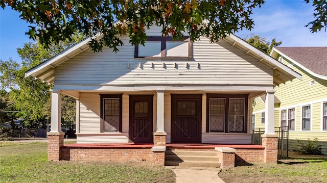 view of front of house with a porch and a front lawn