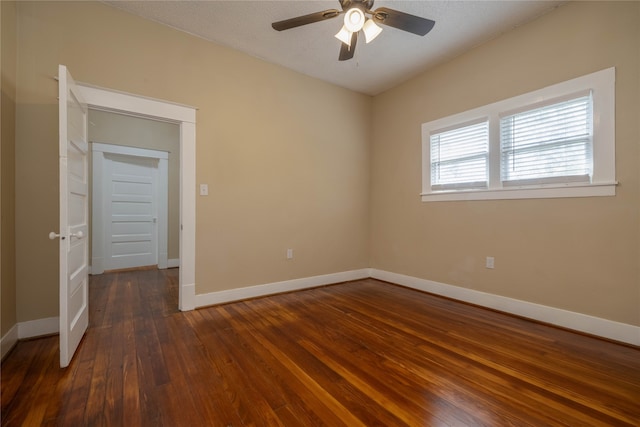 empty room featuring a textured ceiling, ceiling fan, and dark wood-type flooring