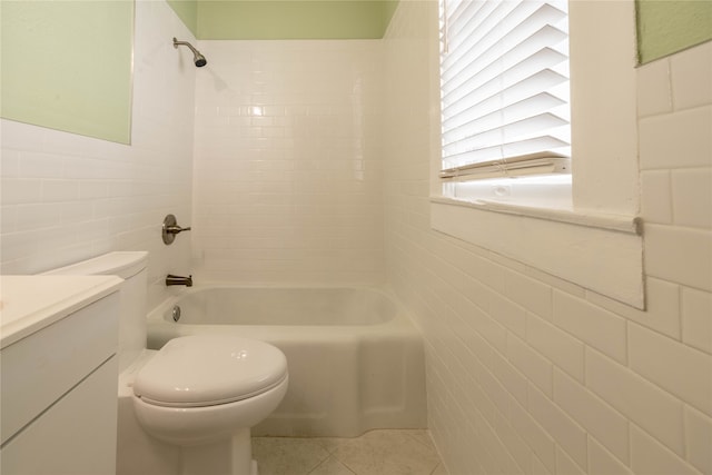 full bathroom featuring tile patterned floors, toilet, vanity, tile walls, and tiled shower / bath