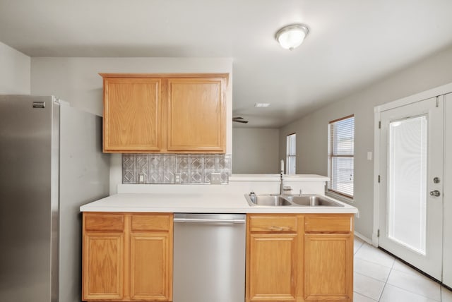 kitchen with sink, light brown cabinetry, tasteful backsplash, light tile patterned flooring, and stainless steel appliances