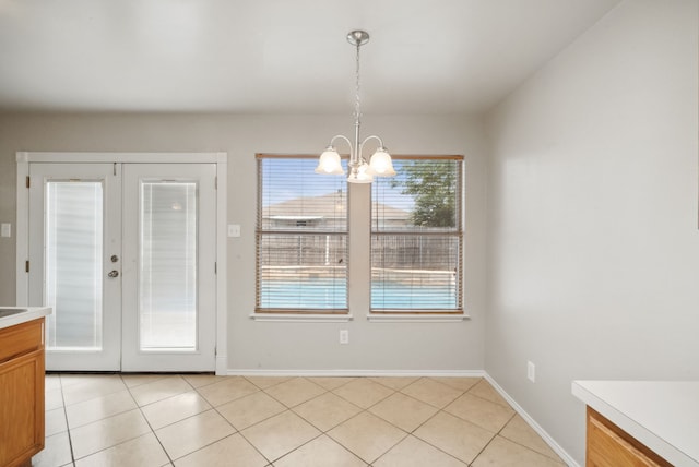 unfurnished dining area featuring french doors, light tile patterned floors, and a chandelier