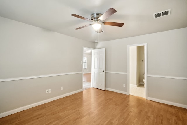 unfurnished bedroom with light wood-type flooring, ceiling fan, and connected bathroom