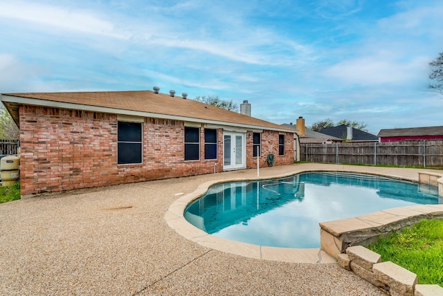 view of swimming pool with french doors