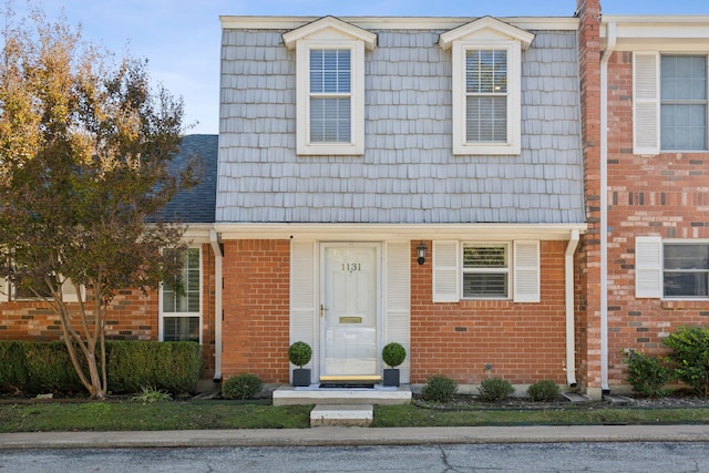 townhome / multi-family property with brick siding and mansard roof