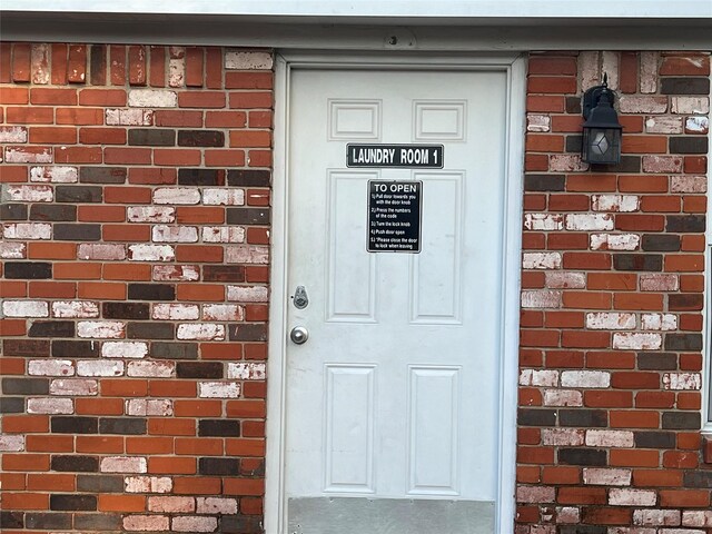 entrance to property featuring brick siding