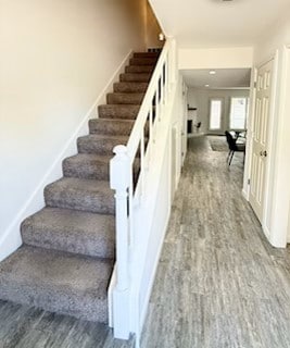 stairs with wood finished floors and baseboards