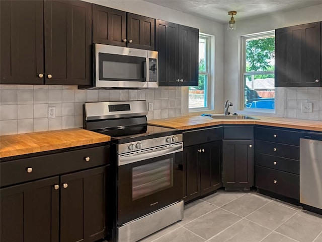 kitchen featuring appliances with stainless steel finishes, butcher block counters, and a sink