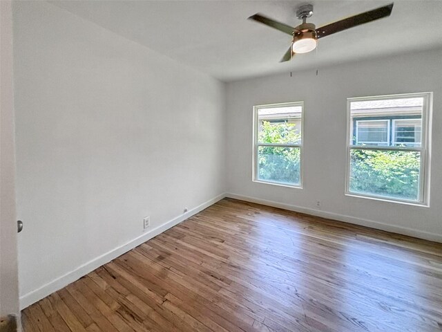 unfurnished room featuring wood finished floors, baseboards, and ceiling fan