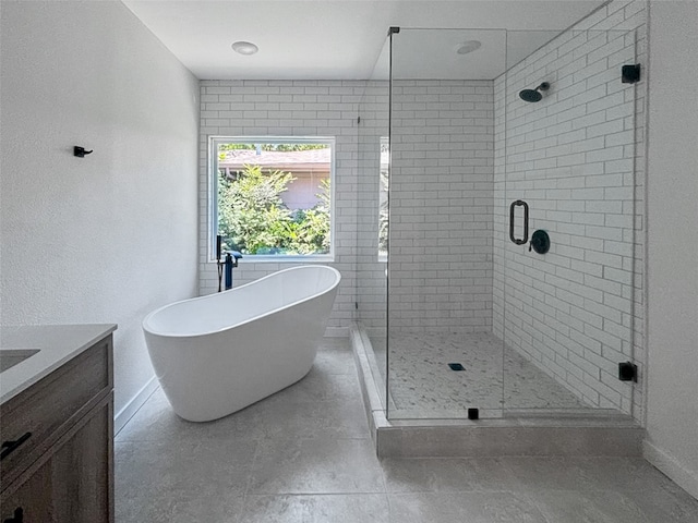 full bathroom featuring a freestanding tub, baseboards, a stall shower, and vanity