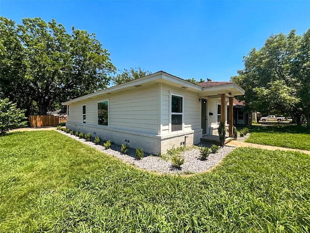 view of side of property with crawl space and a yard