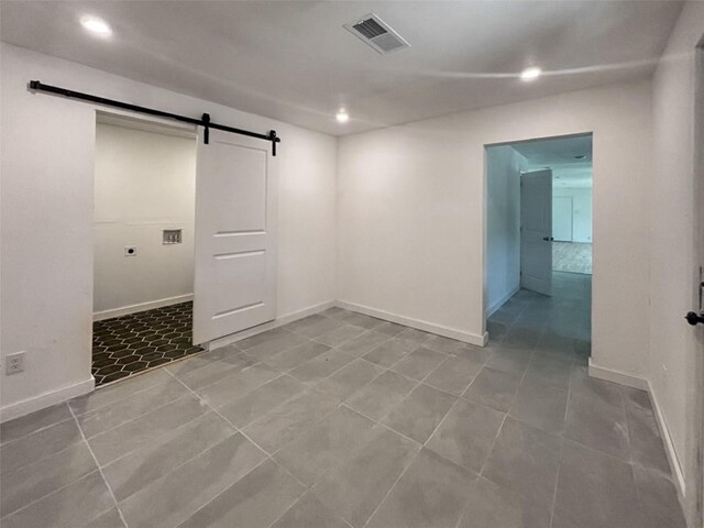 spare room with tile patterned floors, visible vents, recessed lighting, a barn door, and baseboards