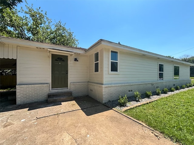 exterior space with entry steps, a front lawn, and crawl space