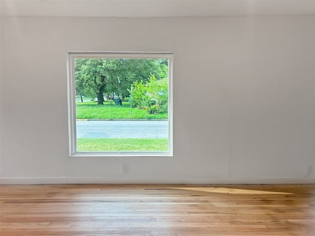 unfurnished room with light wood finished floors and baseboards