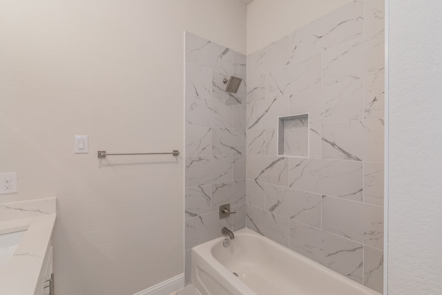 bathroom with vanity and tiled shower / bath