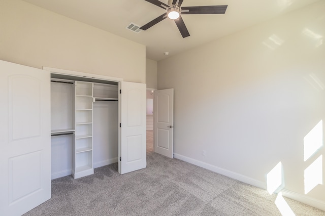 unfurnished bedroom featuring a closet, light colored carpet, and ceiling fan