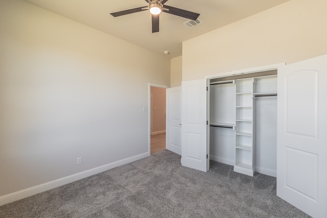 unfurnished bedroom with dark colored carpet, a closet, and ceiling fan