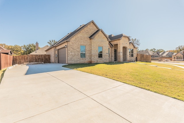 view of front of home featuring a garage and a front lawn