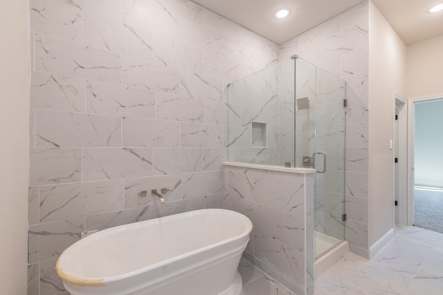 bathroom featuring tile walls and independent shower and bath