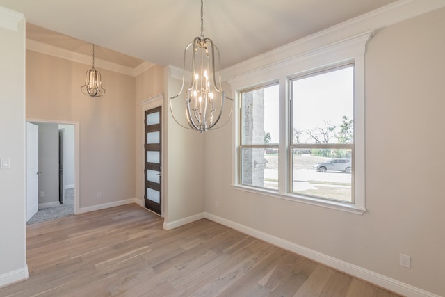 unfurnished dining area featuring a notable chandelier, light wood-type flooring, and crown molding