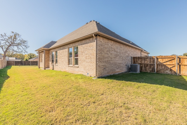 back of property featuring a lawn and central AC unit