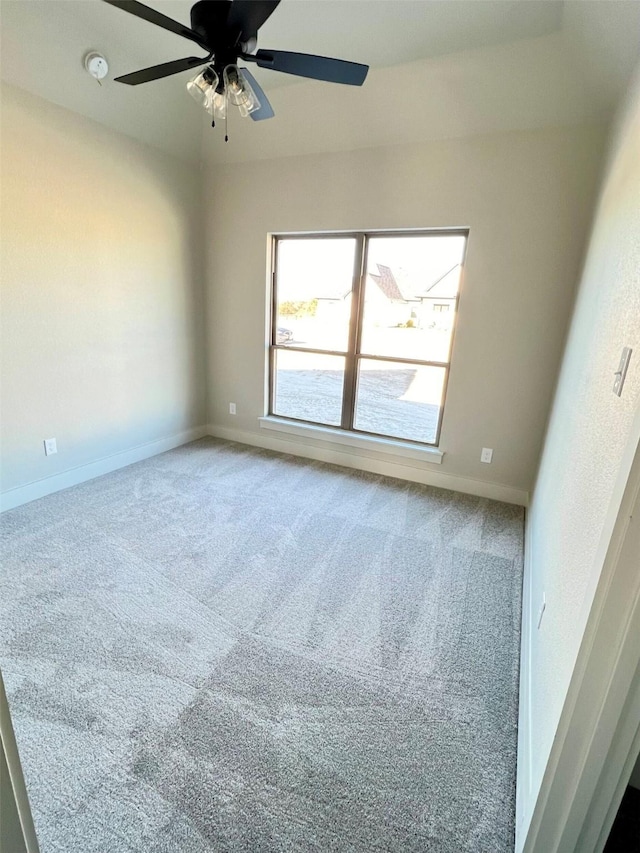 carpeted spare room featuring ceiling fan