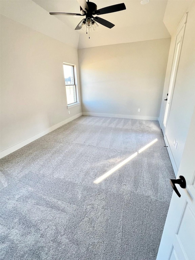 carpeted empty room featuring ceiling fan and lofted ceiling