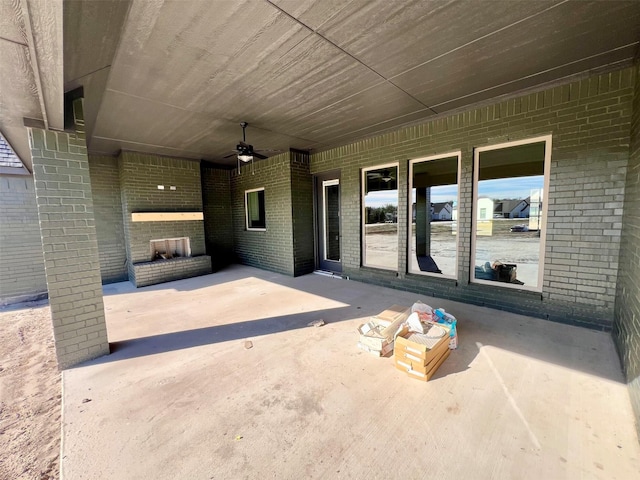 view of patio featuring an outdoor brick fireplace and ceiling fan