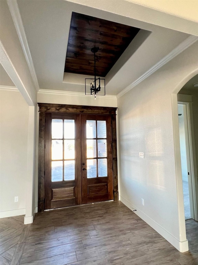 entryway featuring a chandelier, wood-type flooring, crown molding, french doors, and a tray ceiling