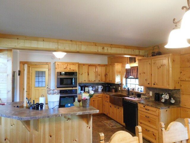 kitchen with sink, pendant lighting, a breakfast bar area, light brown cabinetry, and black appliances