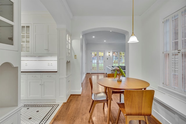 kitchen featuring pendant lighting, high quality appliances, white cabinets, ventilation hood, and tasteful backsplash