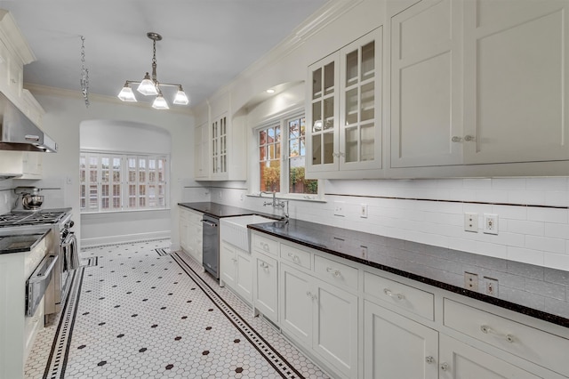 kitchen with white microwave, wall chimney range hood, decorative light fixtures, high end stainless steel range, and white cabinets